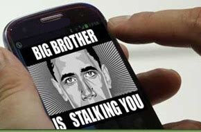 une main tient un smartphone sur lequel il y a une image où il est écrit "Big Brother is talking you"